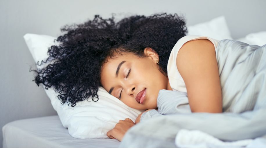 A Black women laying in bed, sleeping