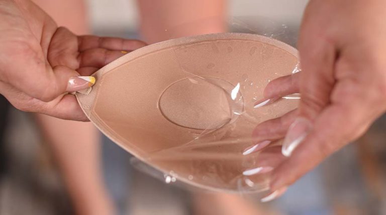 A person holding the cup of an adhesive bra.