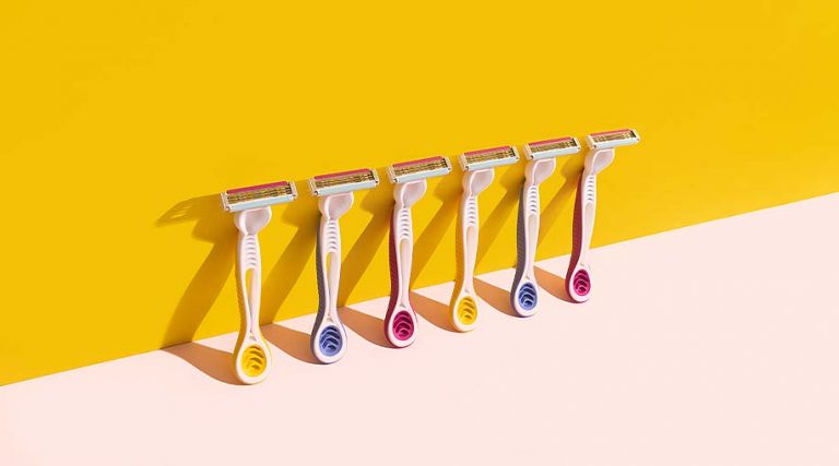 A line of razors against a yellow and pink background.