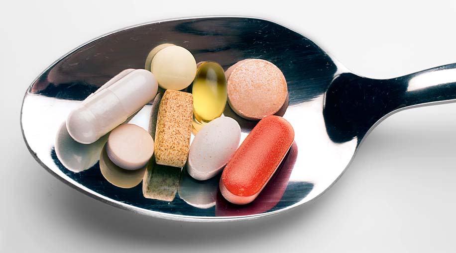 A spoon full of different supplements.